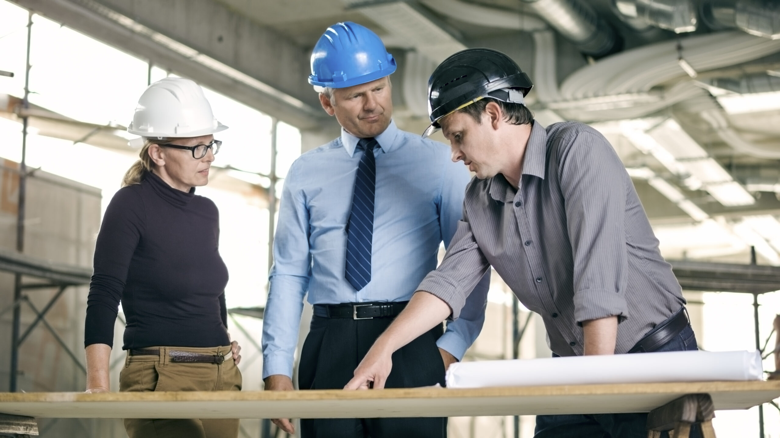 Male architect and female construction coordinator talking to investor on the site of construction Startseite Kreis links scaled